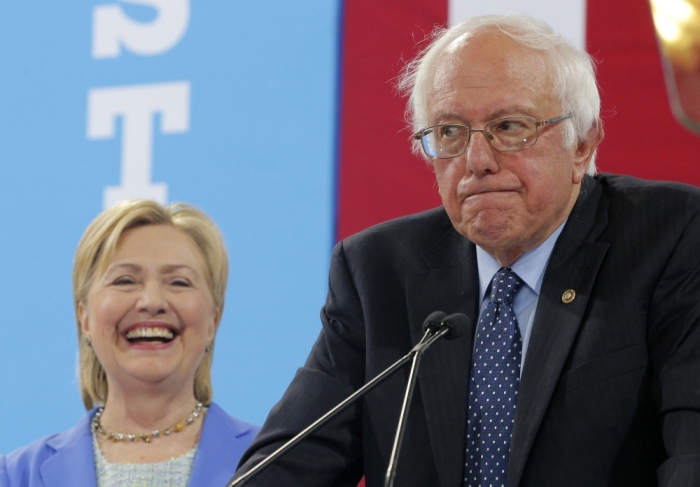 Hillary Clinton smiles as Bernie Sanders pauses while endorsing her during a campaign rally in Portsmouth, New Hampshire.