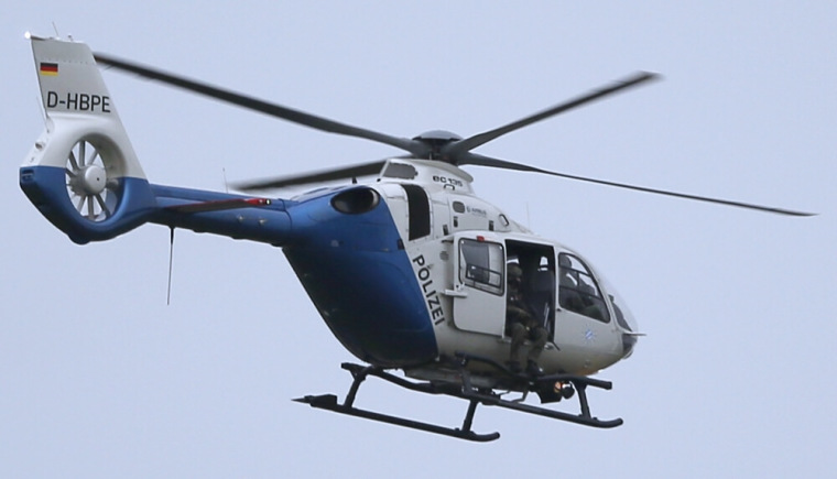 A police sniper sits in a helicopter above the scene of a shooting rampage at the Olympia shopping mall in Munich, Germany, July 22, 2016.