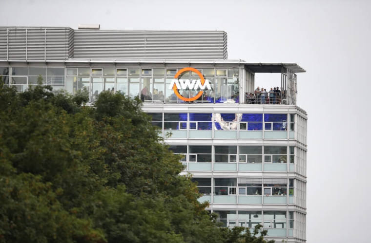 People stand on a balcony of a building overlooking the scene of a shooting rampage at the Olympia shopping mall in Munich, Germany, July 22, 2016.