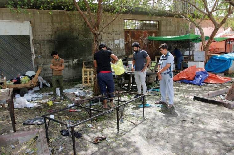 People gather at the site where a suicide bomber detonated his explosive vest at the entrance to Kadhimiya, a mostly Shi'ite Muslim district in northwest Baghdad, Iraq, July 24, 2016.