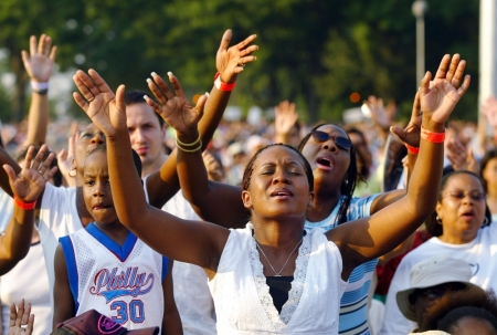 People sing praises during the second day of evangelist Billy Graham's Crusade at Flushing Meadows Park in New York June 25, 2005. Billy Graham, 86, has preached the Gospel to more people in a live audience format thean anyone in history-over 210 million people in more than 185 countries. His followers believe that the New York Crusade which runs from June 24th to the 26th will be his last live appearance.