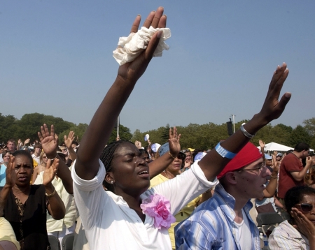 Followers pray before the start of television evangelist Billy Graham's New York Crusade at Flushing Meadows Park in New York on June 26, 2005. Considered the father of American evangelism, the stately Graham has preached to 210 million people in 185 countries and written 24 books, many of them bestsellers.