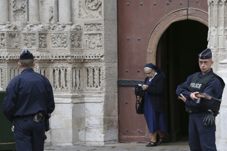 Armed French police stand guard as a nun leaves the Cathedral in Rouen after a funeral service in memory of slain French parish priest Father Jacques Hamel in Rouen, France, August 2, 2016. Father Jacques Hamel was killed last week in an attack on a church at Saint-Etienne-du-Rouvray near Rouen that was carried out by assailants linked to Islamic State.