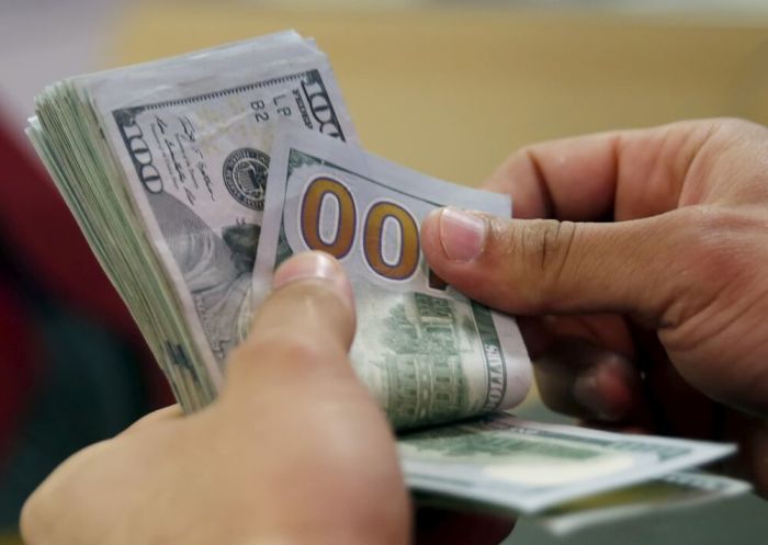 A customer counts his U.S. dollar money in a bank in Cairo, Egypt, March 10, 2016.