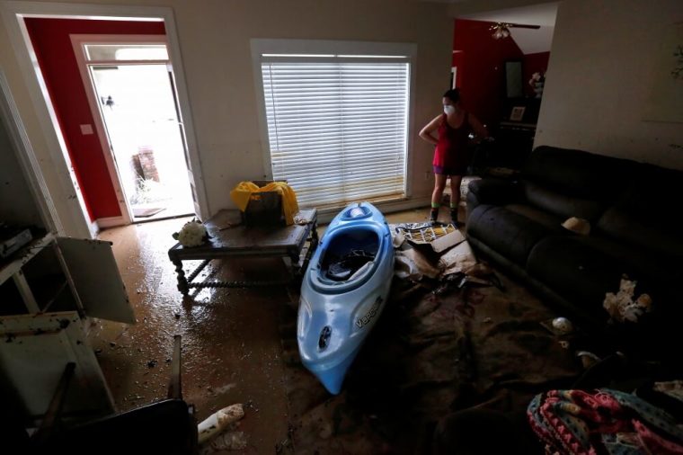 Johnette Folse stands in her flood damaged living room in Denham Springs, Louisiana, U.S., August 16, 2016. Folse said she used the kayak seen in the photo to rescue her animals all of whom survived the flood.