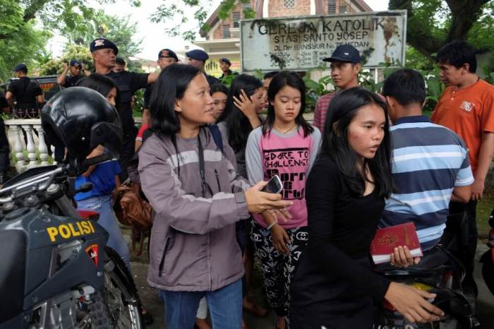 People are seen outside Saint Joseph catholic church following a suspected terror attack by a knife-wielding assailant on a priest during the Sunday service in Medan, North Sumatra, Indonesia, August 28, 2016.